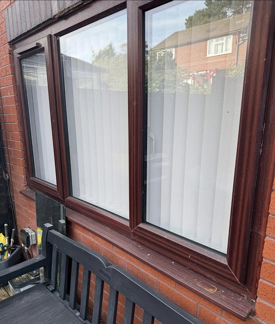 Dirty brown uPVC window with marked sill before cleaning